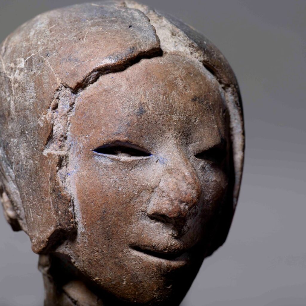 Figurilla de cerámica que representa la cabeza de una mujer con cabello corto