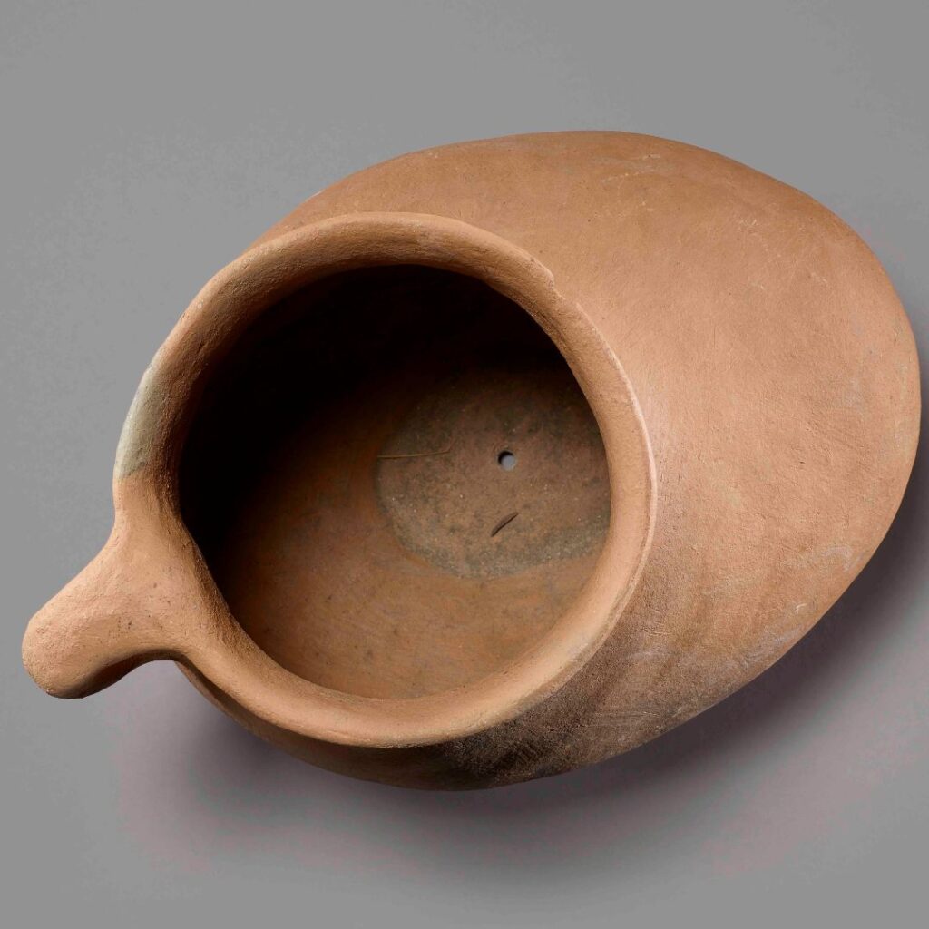 Brown pottery jug with a handle, shown from a bird-eye perspective