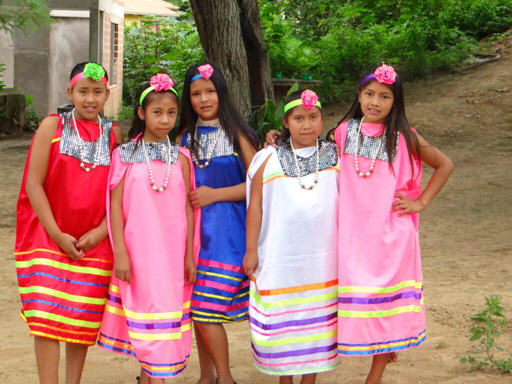 Photo of five young women wearing stripped dresses in different colours (red, pink, blue and white) and head-dresses