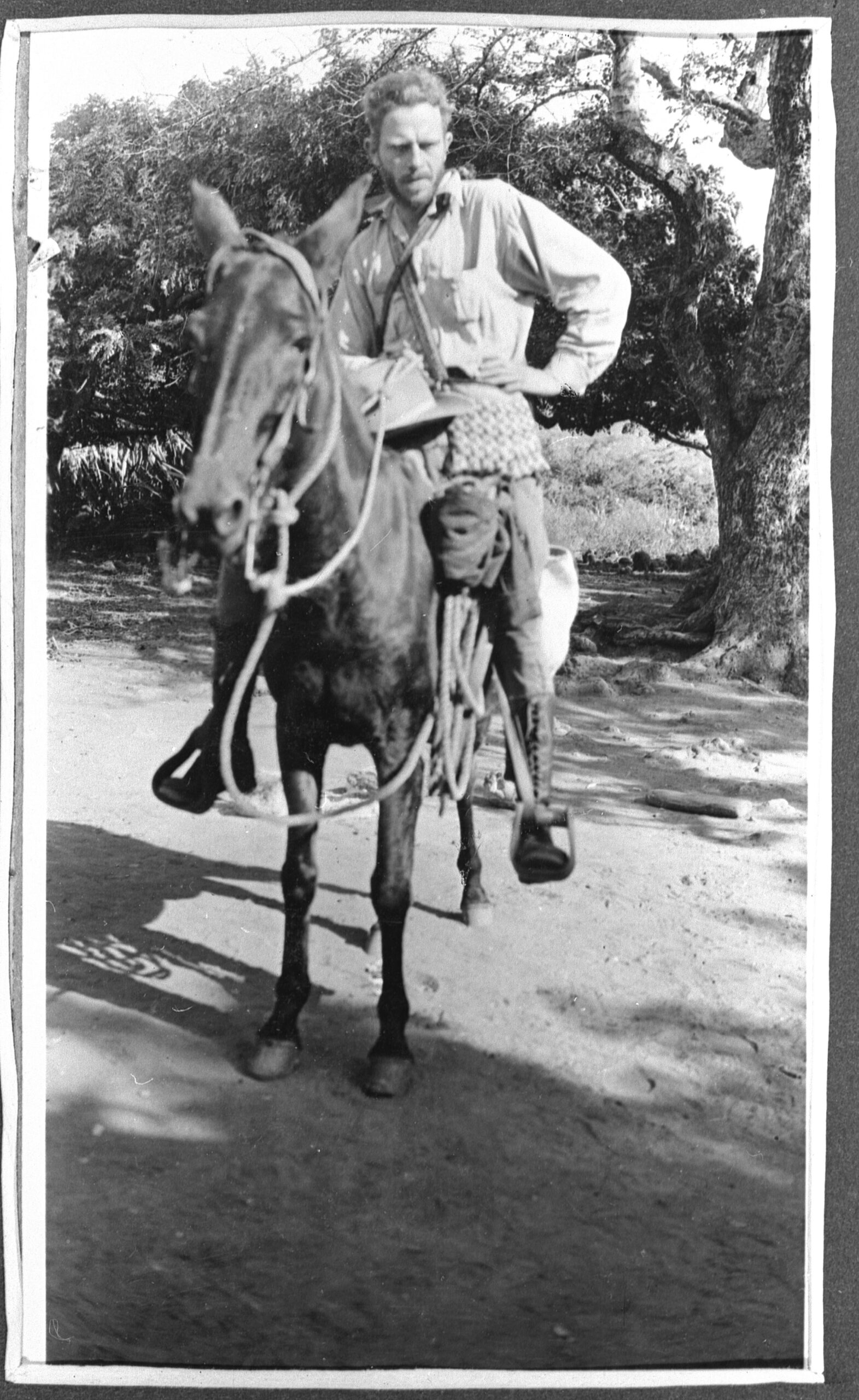 Black and white photo of a man riding a horse